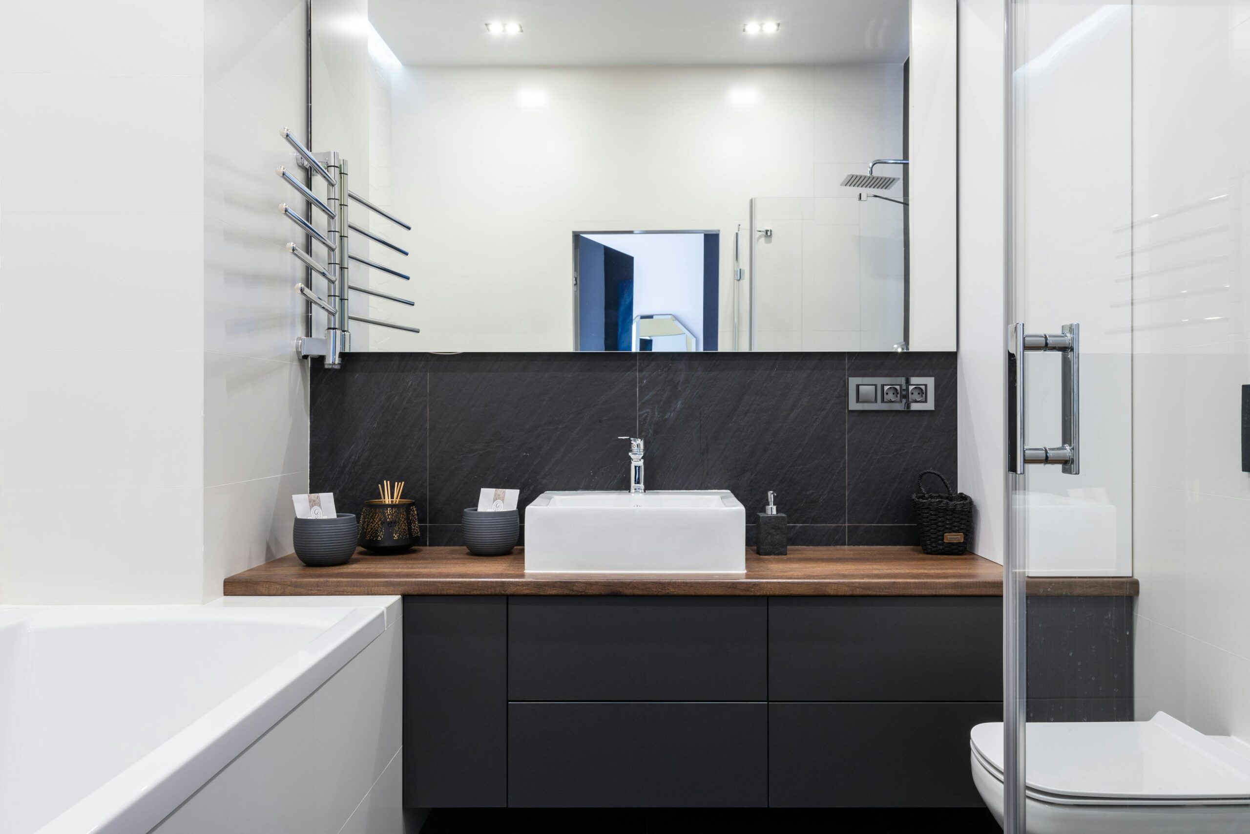 Sleek and contemporary bathroom design featuring a modern sink, bathtub, and glass shower enclosure.